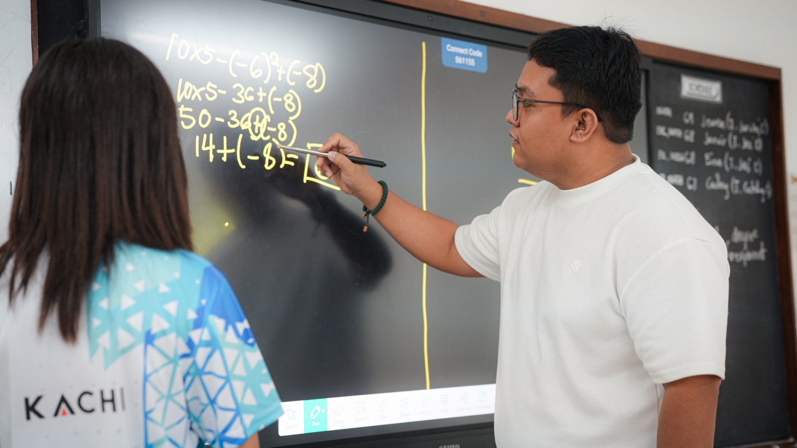 A teacher demonstrating a lesson on a classroom smartboard